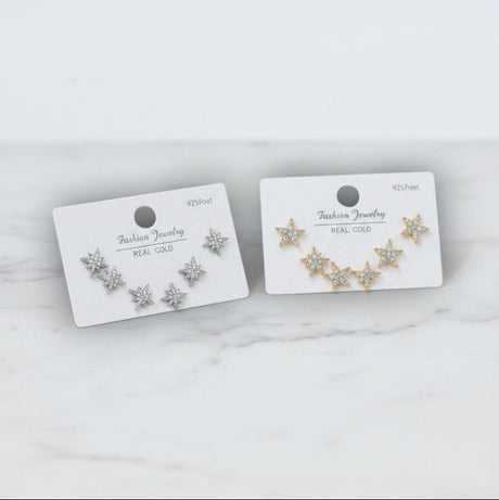 Pair of star stud earring sets on display cards with branding on a marble surface