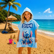 Girl wearing a blue stitch hooded poncho on the beach
