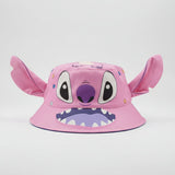 Pink character bucket hat with large ears, big eyes and a toothy smile on a plain backdrop