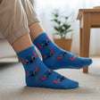 Kids blue crew socks covered in repeating blue Stitch faces with pink inner ears, worn on feet