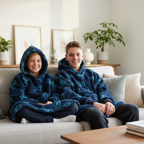 Two kids on a sofa in matching navy Stitch hooded blankets