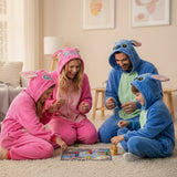 Family playing a board game together in matching pink and blue stitch-themed onesies.