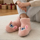 Person wearing pink stitch pantoufle on a carpeted floor with gift boxes in the background