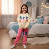 Girls set with a cream Stitch print sweatshirt and hot pink joggers worn in a bedroom