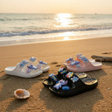 Stitch charm slides in white, pink and black lined up on sunset beach sand