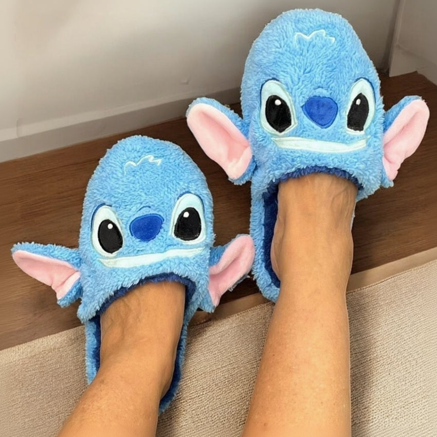 Both feet in cornflower towelling mules on a carpeted stair, seen from above