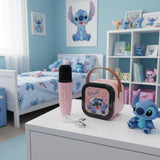 Pink speaker and microphone laid out with the charging cable on a bedroom dresser