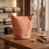 Coral stitched bucket crossbody bag with knotted side tabs