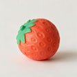 Red strawberry squishy toy with a dimpled surface and green leafy top on a white background