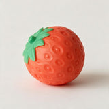 Red strawberry squishy toy with a dimpled surface and green leafy top on a white background