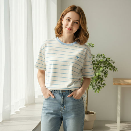 Blue striped tee worn with jeans beside a house plant