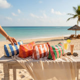 Colorful striped beach bags on a table with a scenic beach background