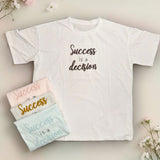 White t-shirt with 'Success is a decision' text surrounded by flowers on a light background