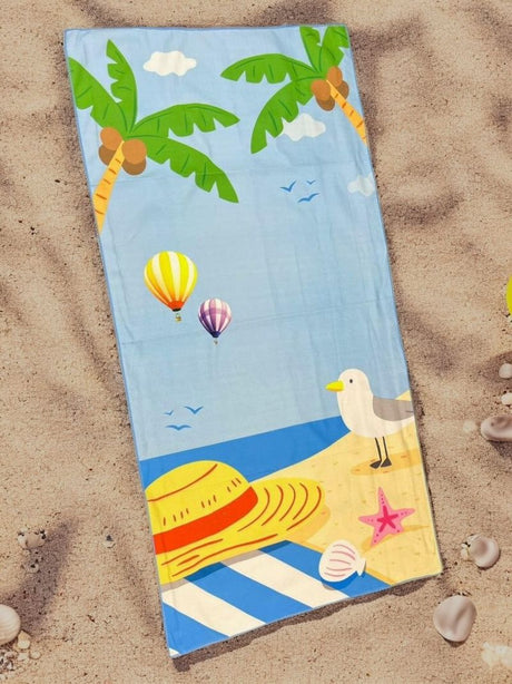 Beach towel with tropical design featuring palm trees, hot air balloons, and a seagull on sand.