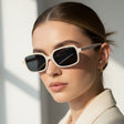 Woman wearing white sun chic sunglasses with a neutral background