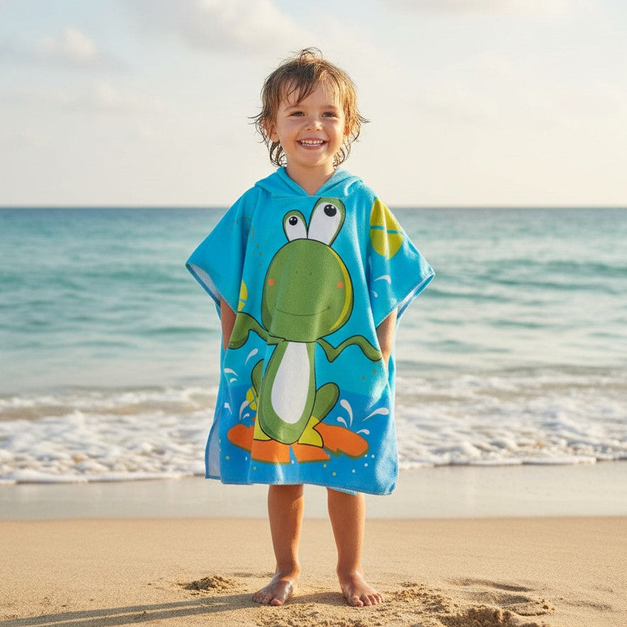 Child wearing an aqua poncho towel with a green frog riding an orange surfboard