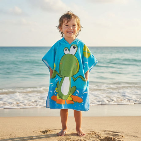 Child wearing an aqua poncho towel with a green frog riding an orange surfboard