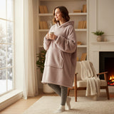 Taupe hooded blanket worn standing in a bright room with a snowy window behind