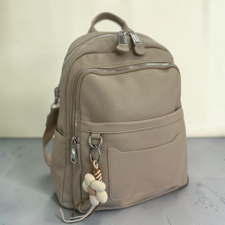 Taupe grained backpack with twin front zips and a woven daisy charm