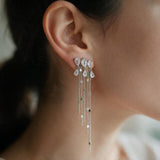 Silver teardrop crystal cluster earring with long sequin chain tassels worn on the ear