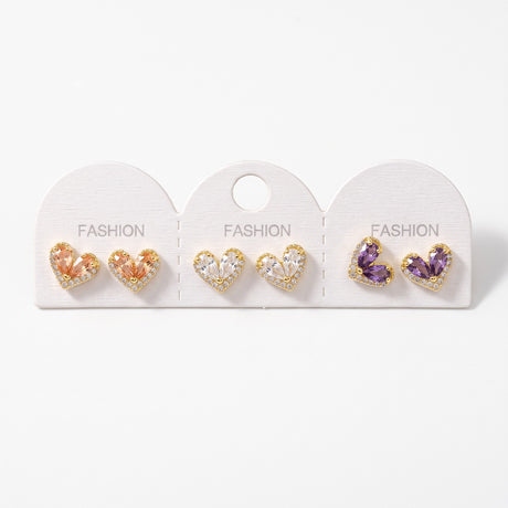 Three pairs of teardrop crystal heart stud earrings in peach, clear and purple