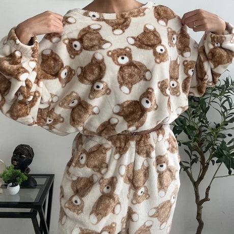 Close view of a cream fleece top with a brown teddy bear print