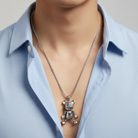 Silver jointed teddy bear pendant on a box chain over a blue shirt, Jack Gifts Online Lebanon