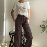 Teddy bear print crop tee worn with brown trousers and hands in pockets