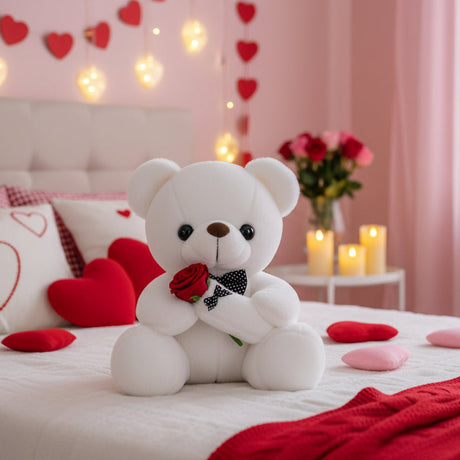 White plush bear holding a red rose tied with a polka dot ribbon on a decorated bed