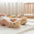 Oatmeal terry newborn booties with a plush teddy bear face and grey dotted non slip sole