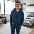 Teen boy in a denim blue zip up hooded jacket with matching blue joggers in a bedroom