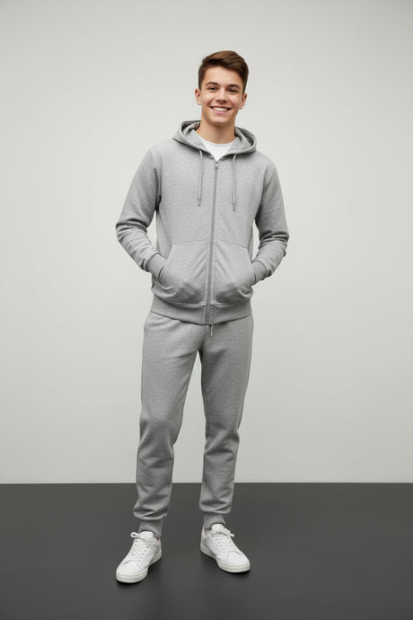 Teenage boy in a grey zip up hooded jacket and matching grey joggers with white sneakers