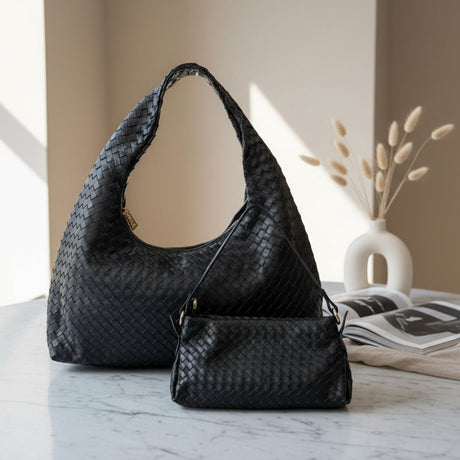 Black woven handbag on a marble surface with a neutral background