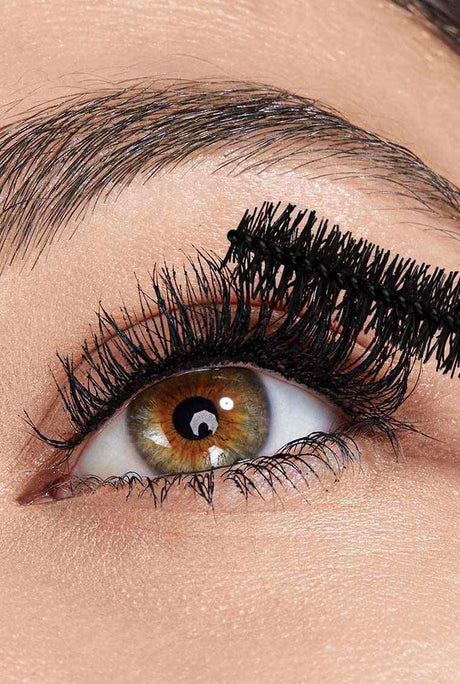 Eye close up with the wand applying mascara for a lifted false lash effect