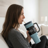 Dusty blue matte tumbler with a black lid, loop handle and cream straw