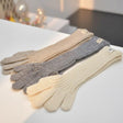 Three pairs of long gloves in beige, grey, and white on a white surface
