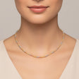 Tri-tone beac necklace with gold and silver beads worn by a person on a white background