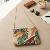 Leaf print tapestry bag laid flat beside sunglasses and a coffee