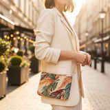 Woman carrying a tropical leaf tapestry bag over a cream blazer