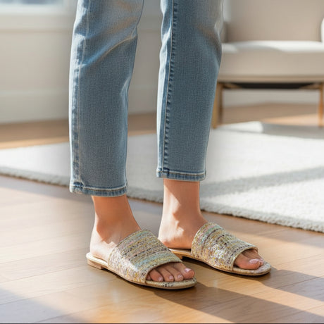 Person wearing blue jeans and tweed handmade slippers indoors
