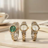 Three two tone watches with green and white dials on a marble table