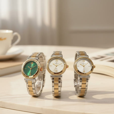 Three two tone watches with green and white dials on a marble table
