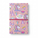A pink 'Unicorn Colouring Book Set' with a whimsical pattern of unicorns, rainbows, stars, and Paris Eiffel Tower silhouettes
