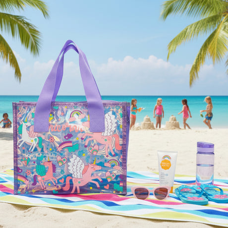 Unicorn print clear tote on a striped beach towel with sunglasses, sunscreen and flip flops