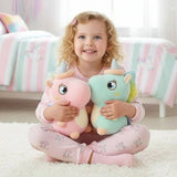 Girl holding a pink and a mint unicorn, both with glitter horns and rainbow manes