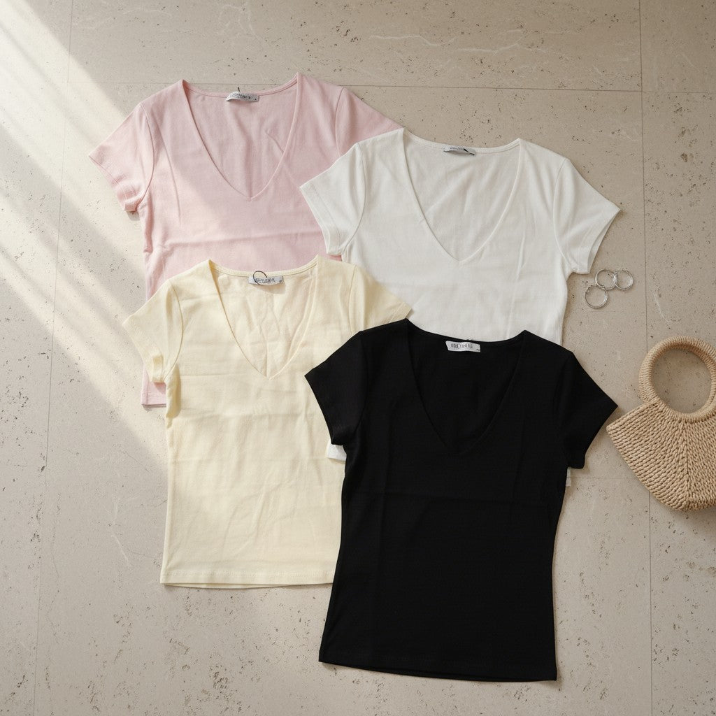 Four short sleeve V neck tees in pale pink, white, yellow and black laid flat