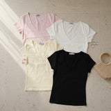 Four short sleeve V neck tees in pale pink, white, yellow and black laid flat