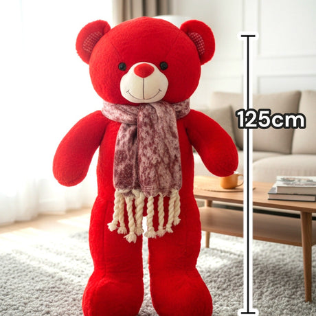 Bright red teddy bear standing in a marled burgundy scarf with cream fringe
