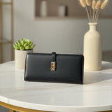 Black wallet on a white table with decorative elements in the background