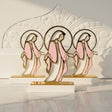 Three acrylic Virgin Mary panels with gold halo rings on white blocks in sunlight